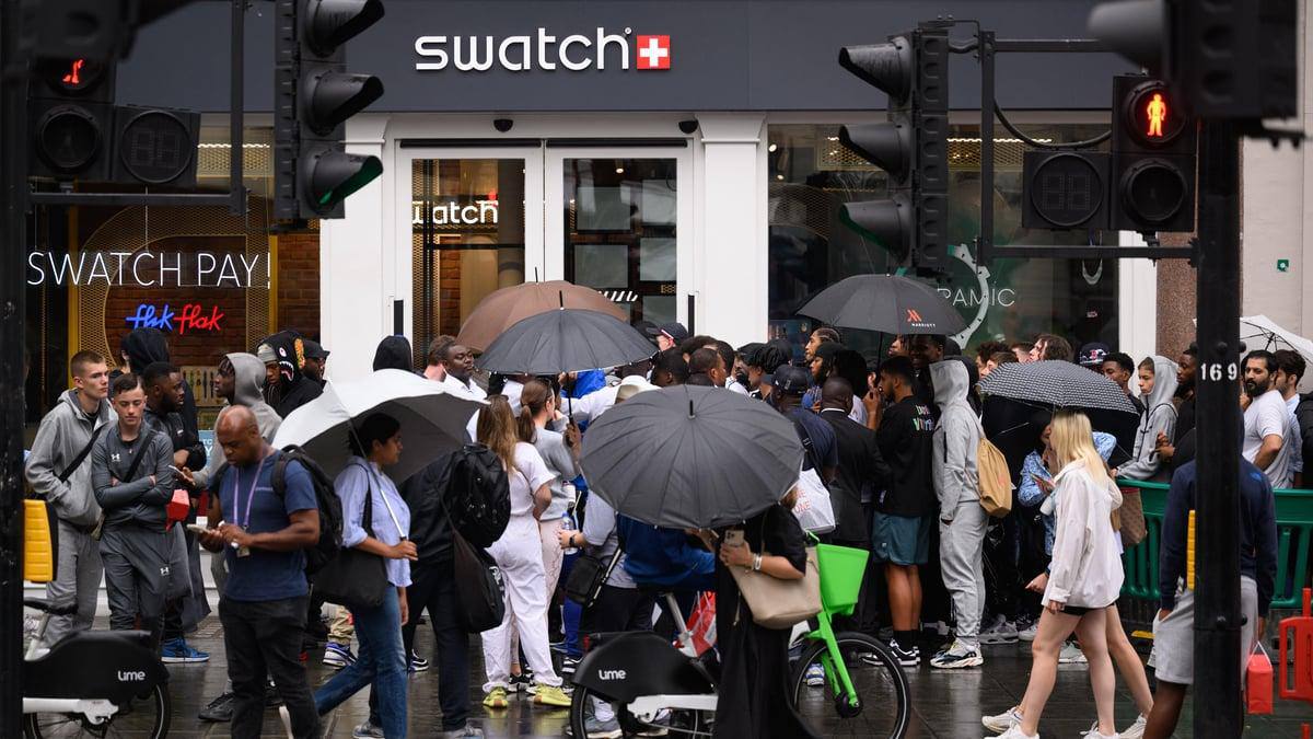 Swatch London crowd in the rain, dozens of umbrellas outside the flagship